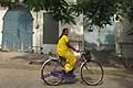 Donna con abito molto colorato in bicicletta a Pondicherry in India