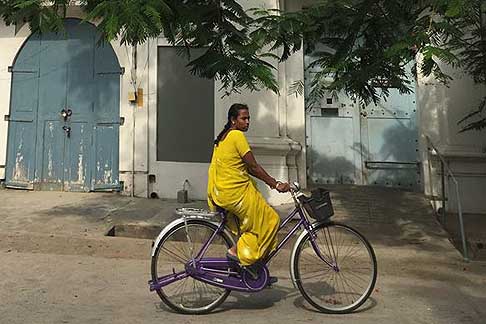 Traffico e atmosfere indiane - Donna con abito molto colorato in bicicletta a Pondicherry in India