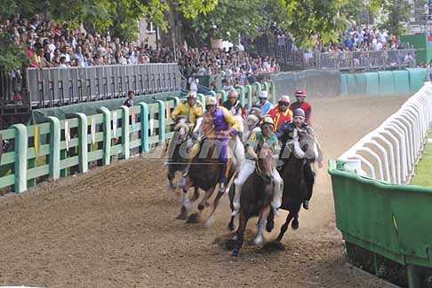 Corsa di Cavalli - Corsa cavalli gara, prima curva al Palio di Ferrara in testa rione Santo Spirito con Enrico Bruschelli detto Bellocchio