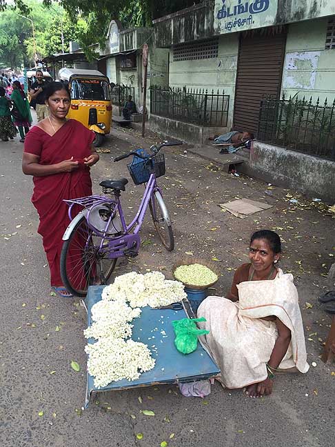 Traffico e atmosfere indiane - Suggestiva immagine di donna che vende fiori di Gelsomino. Le donne lo usano per fare le trecce da mettere tra i capelli