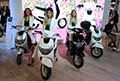 Scooter elettrici Icone Smart e hostess in sella sugli scooter all´Eicma 2021 di Milano a Fiera Rho