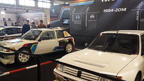 Peugeot - Peugeot 205 Turbo 16 bianco perla e la versione racing cars della Peugeot 205 Turbo sullo sfondo ad Auto e Moto dEpoca di Padova