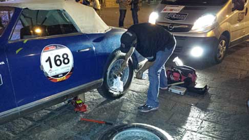 Mille Miglia Bologna - 1000 Miglia 2014 con auto storica in manutenzione e la poca illuminazione della piazza di Bologna