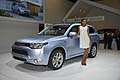 Ragazza che affianca la Mitsubishi Outlander PHEV Suv medio al Salone dellauto di Parigi 2012