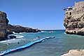 Atleti attraversano in difficolt la passerella galleggiante e scogliera gremita di gente al Red Bull Cliff Diving World Siries 2025 a Polignano a Mare